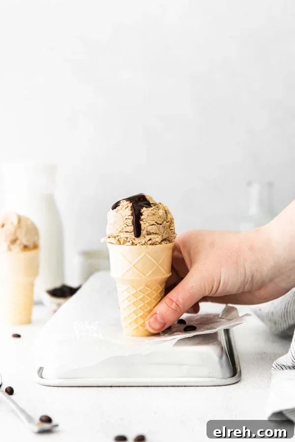a hand picking up an ice cream cone filled with no churn coffee ice cream