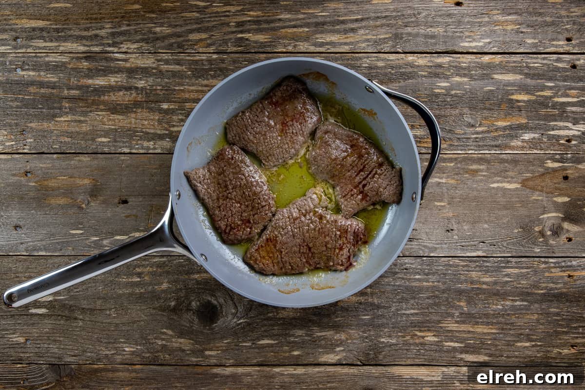 Seared minute steaks in skillet.