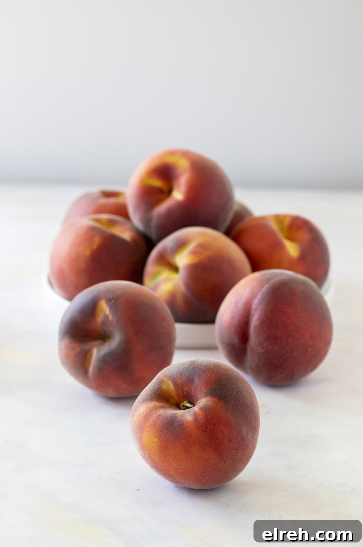 Fresh peaches on a marble countertop.