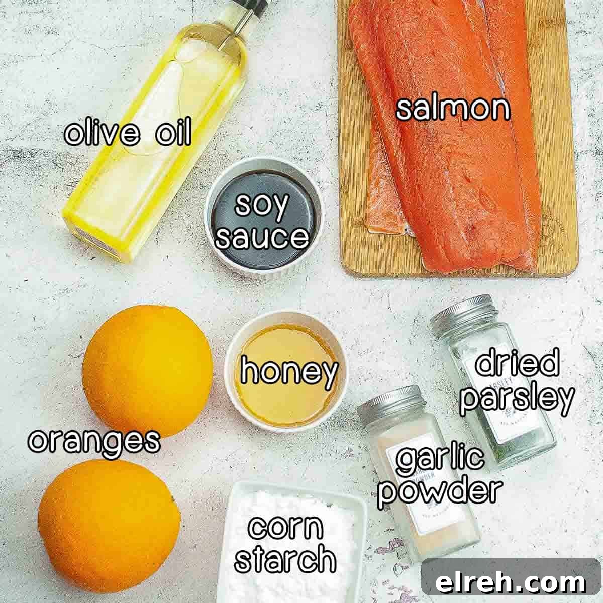 Overhead shot of ingredients - olive oil, salmon, soy sauce, honey, oranges, corn starch, garlic powder, and dried parsley.