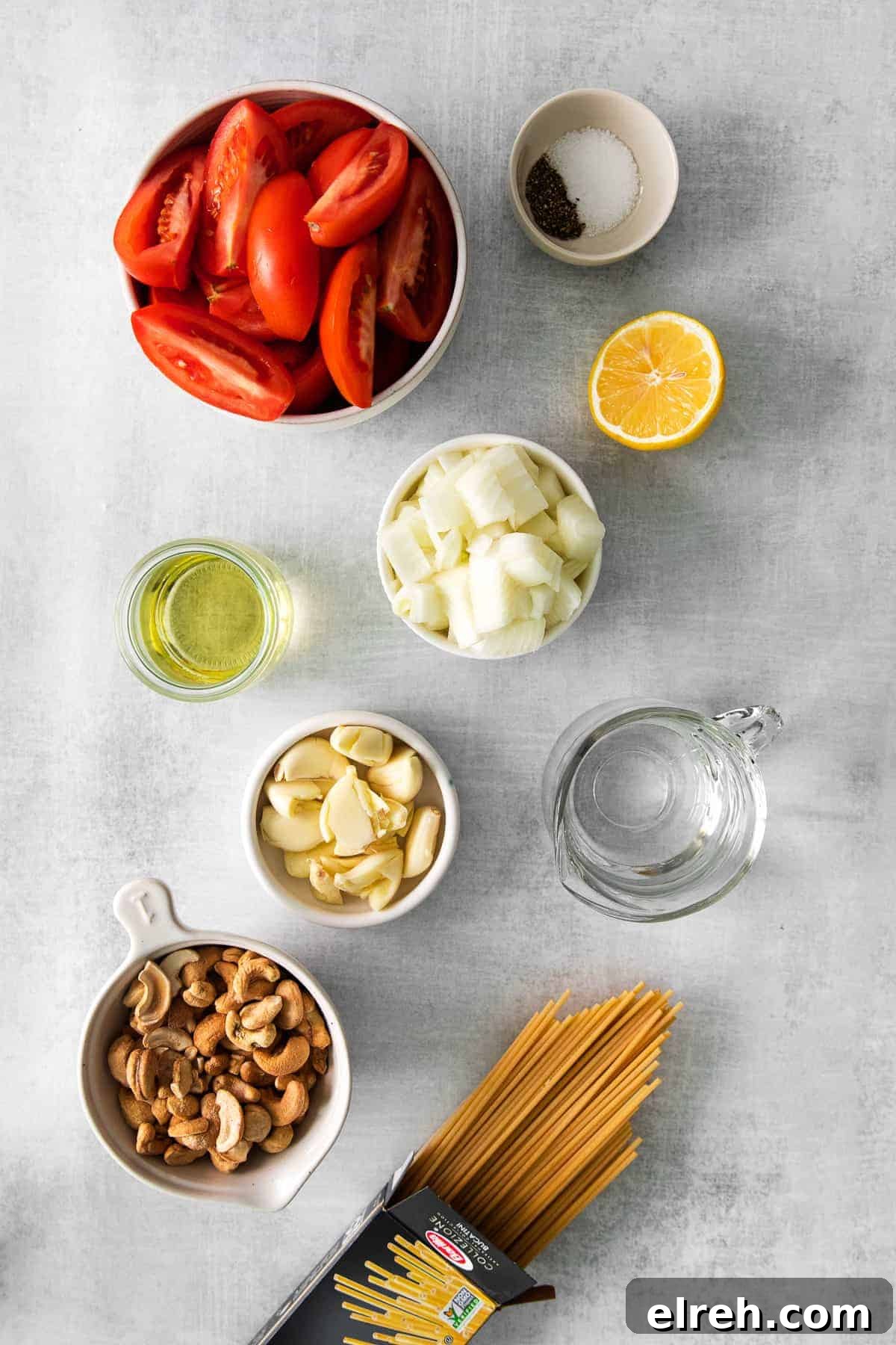 The most delicious creamy vegan pasta is made with soaked cashews, roasted tomatoes, and garlic. Blend it up and serve it with fresh basil and your favorite pasta! ingredients on counter