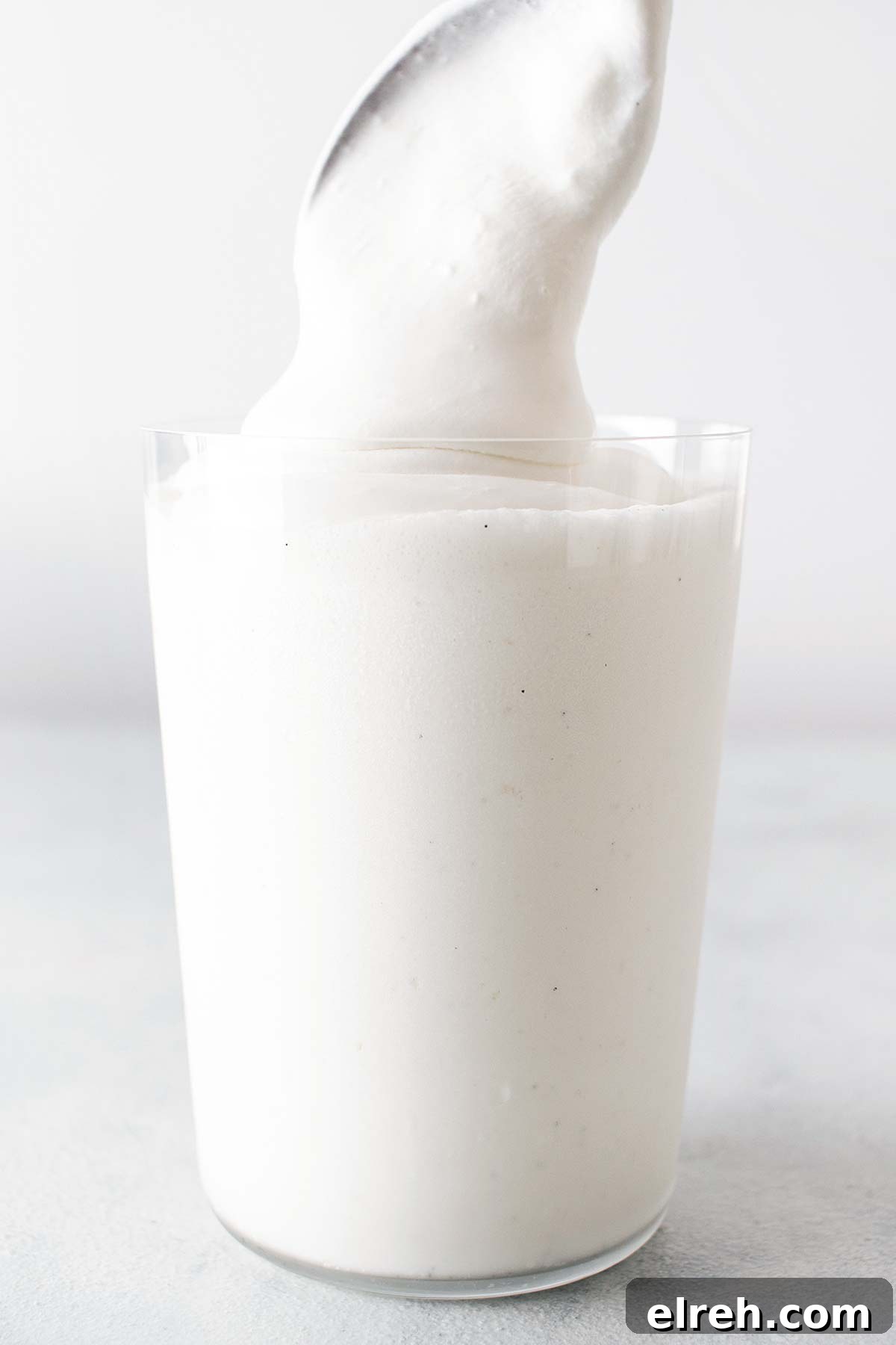 Vanilla Bean Frappuccino Starbucks Copycat Recipe 8 Spooning whipped cream on top of a Frappuccino.