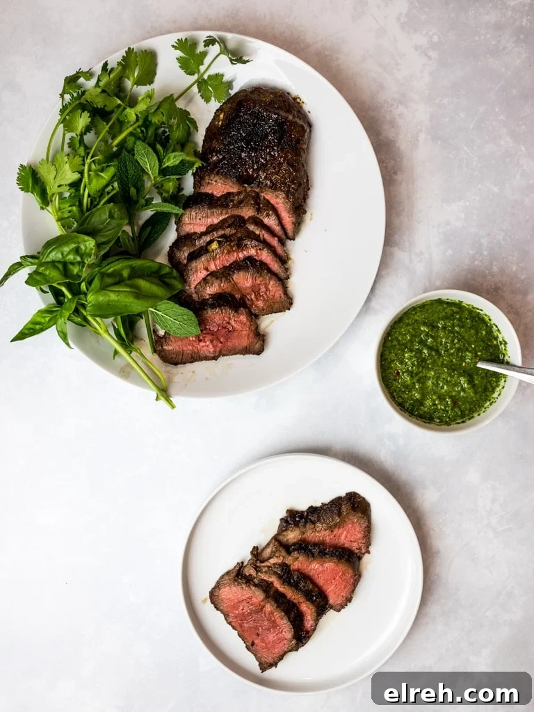 marinated Asian flank steak with spicy Asian chimichurri on white plates with herbs