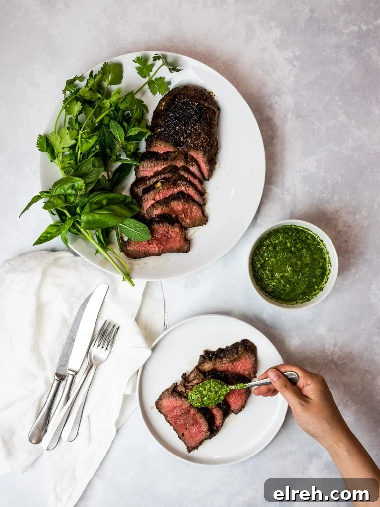 Asian marinated flank steak, spicy Asian chimichurri steak on white plates with herbs