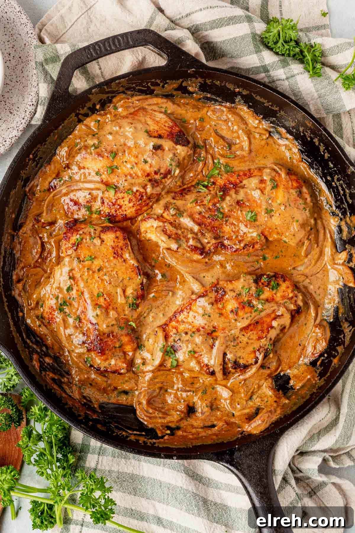 four pieces of boursin chicken in a cast iron skillet.