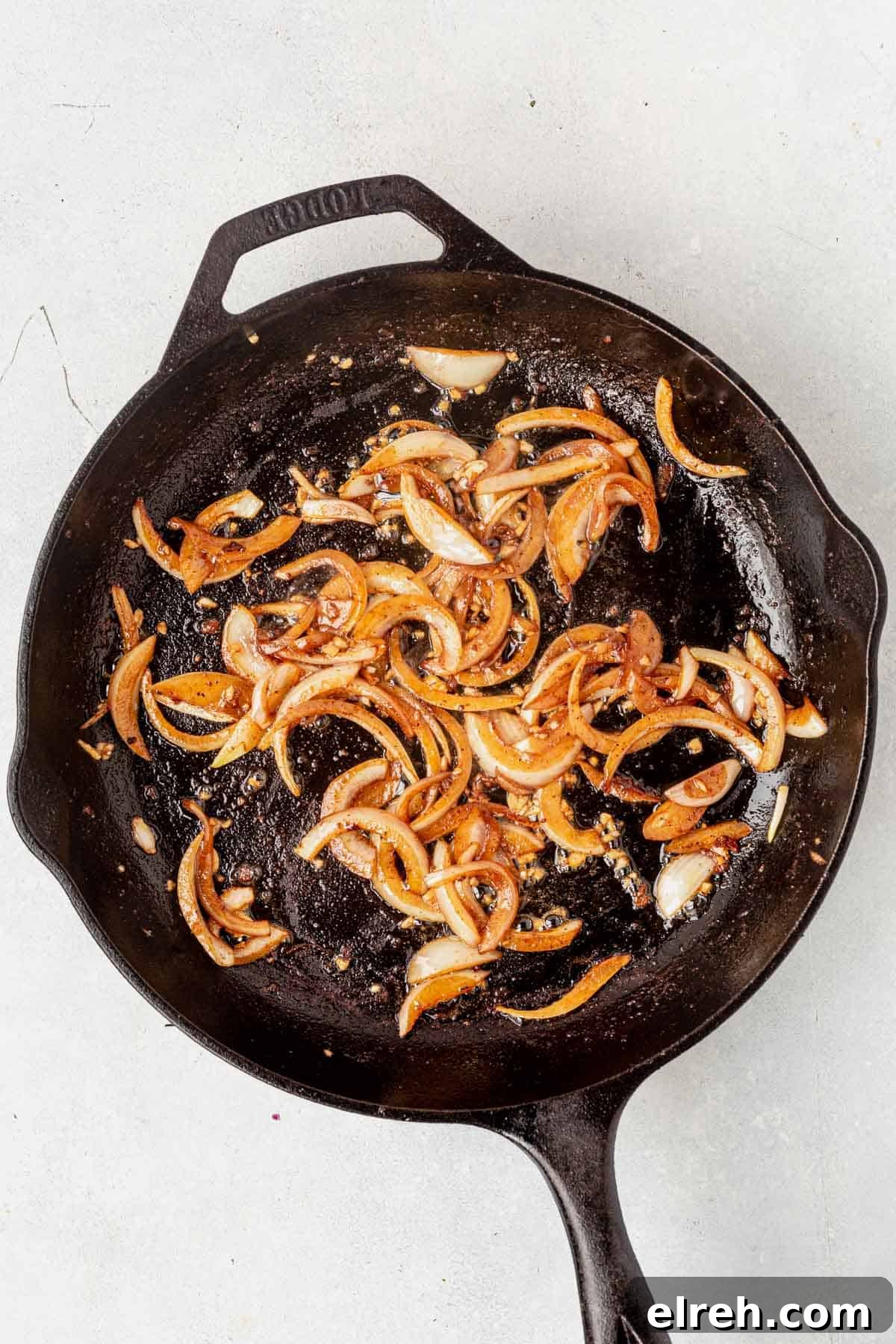 sauteed shallots in a cast iron pan on the stove as part of the boursin chicken recipe