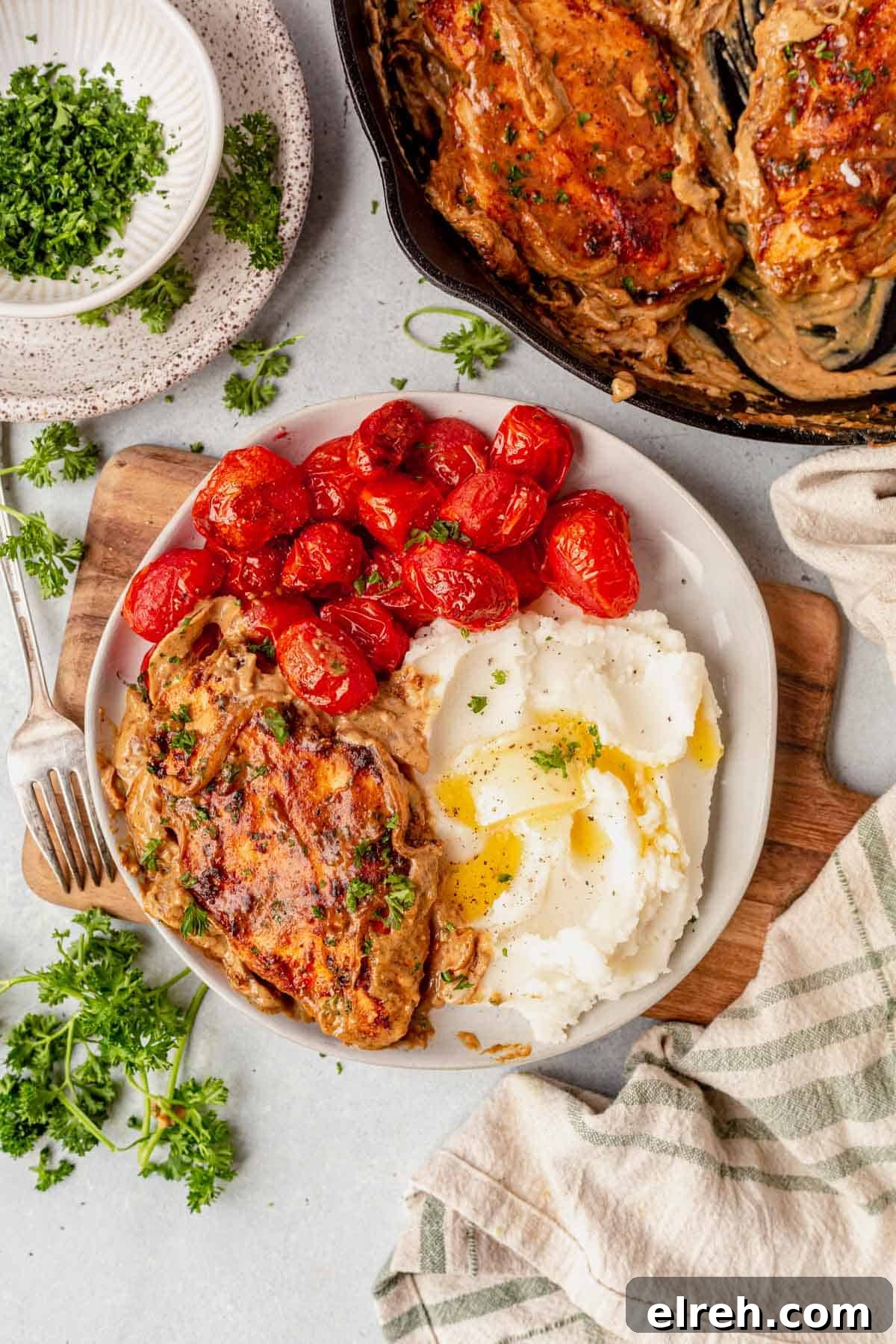 boursin chicken on a plate with cherry tomatoes and mashed potatoes