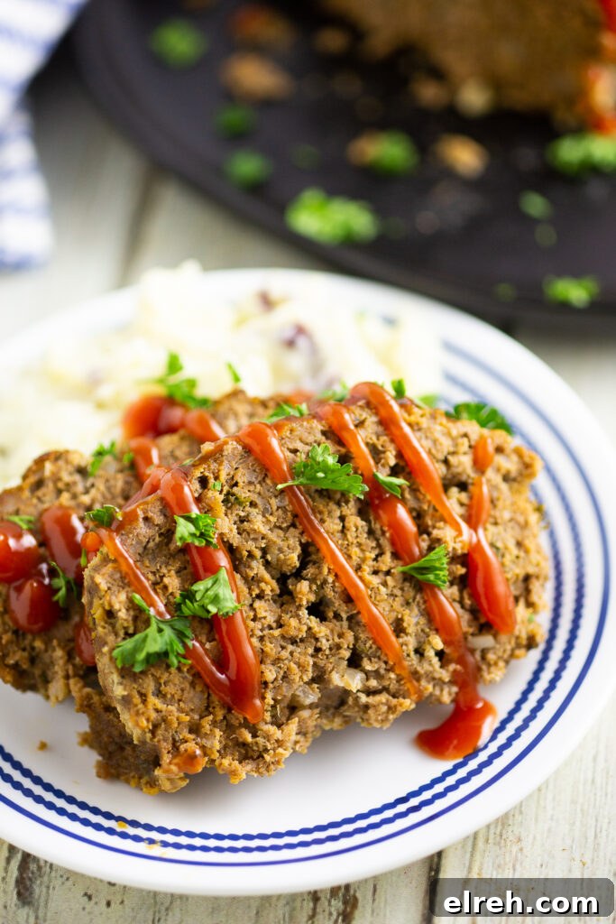 2 slices of meatloaf on a plate with mashed potatoes