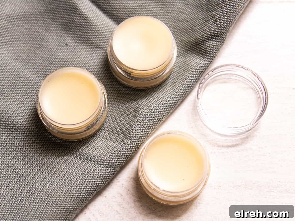How to Make Tallow Lip Balm for Soft, Hydrated Lips 2 Three containers of tallow lip balm on a table with one lid.