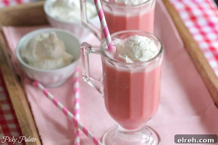 Refreshing Summer Drink Recipes to Beat the Heat 4 Two pink strawberry milk slushies side-by-side, topped with ice cream.