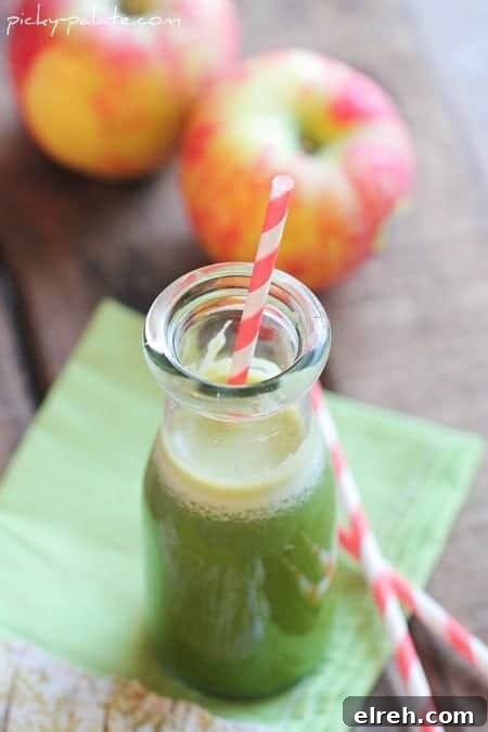 Refreshing Summer Drink Recipes to Beat the Heat 6 Green juice in a glass with a red-striped straw, with apples in the background.