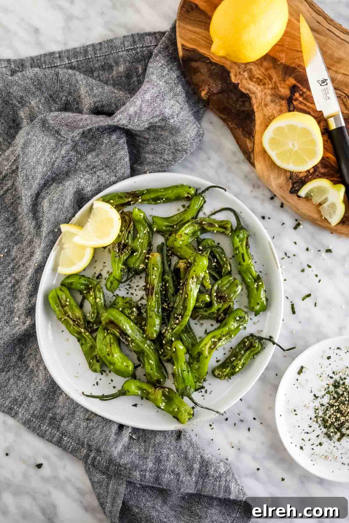 22 Delicious Sides to Serve with Chicken Wings 21 Shishito Peppers with furikake and lemon on plate flatlay.