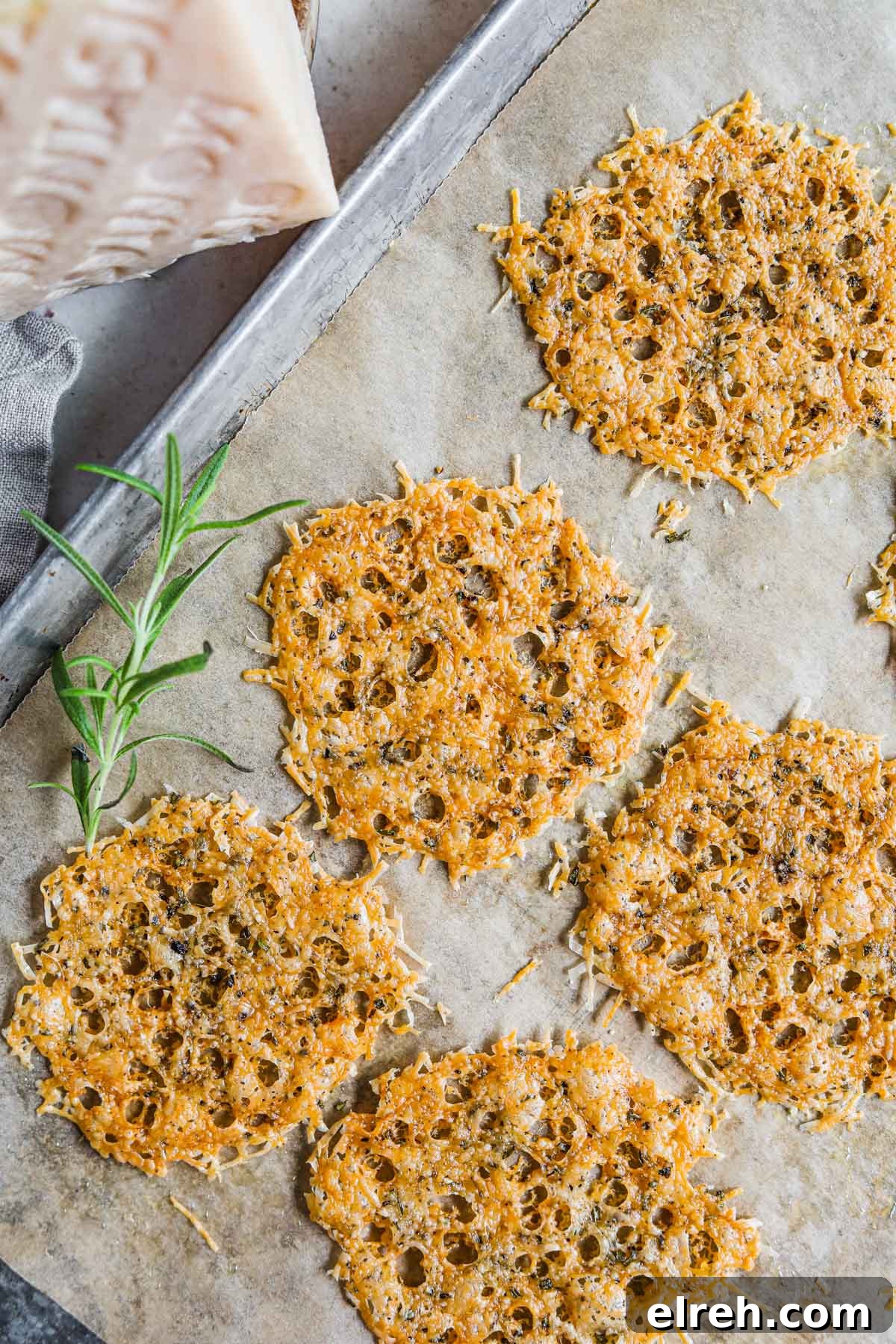 22 Delicious Sides to Serve with Chicken Wings 23 Montasio parmesan frico cheese crisps on a baking sheet with rosemary and black pepper.