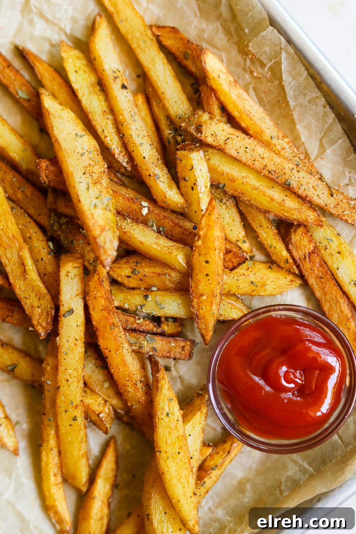22 Delicious Sides to Serve with Chicken Wings 9 Classic seasoned french fries with garlic powder, dried basil, paprika, and ketchup on a baking sheet with parchment paper.