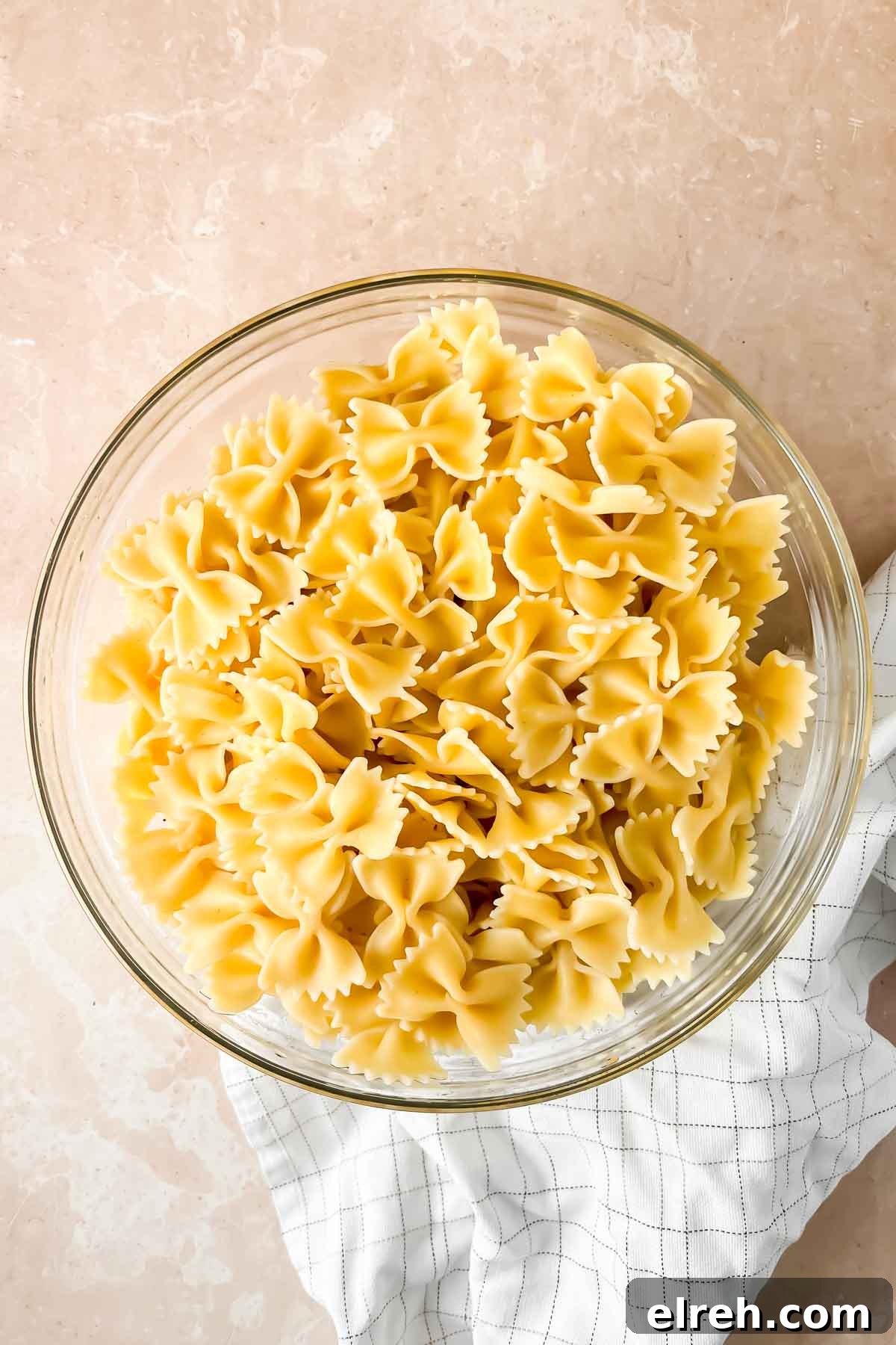 Fall Pasta Salad with Roasted Butternut, Cranberries and Feta 5 bowtie noodles in glass bowl.