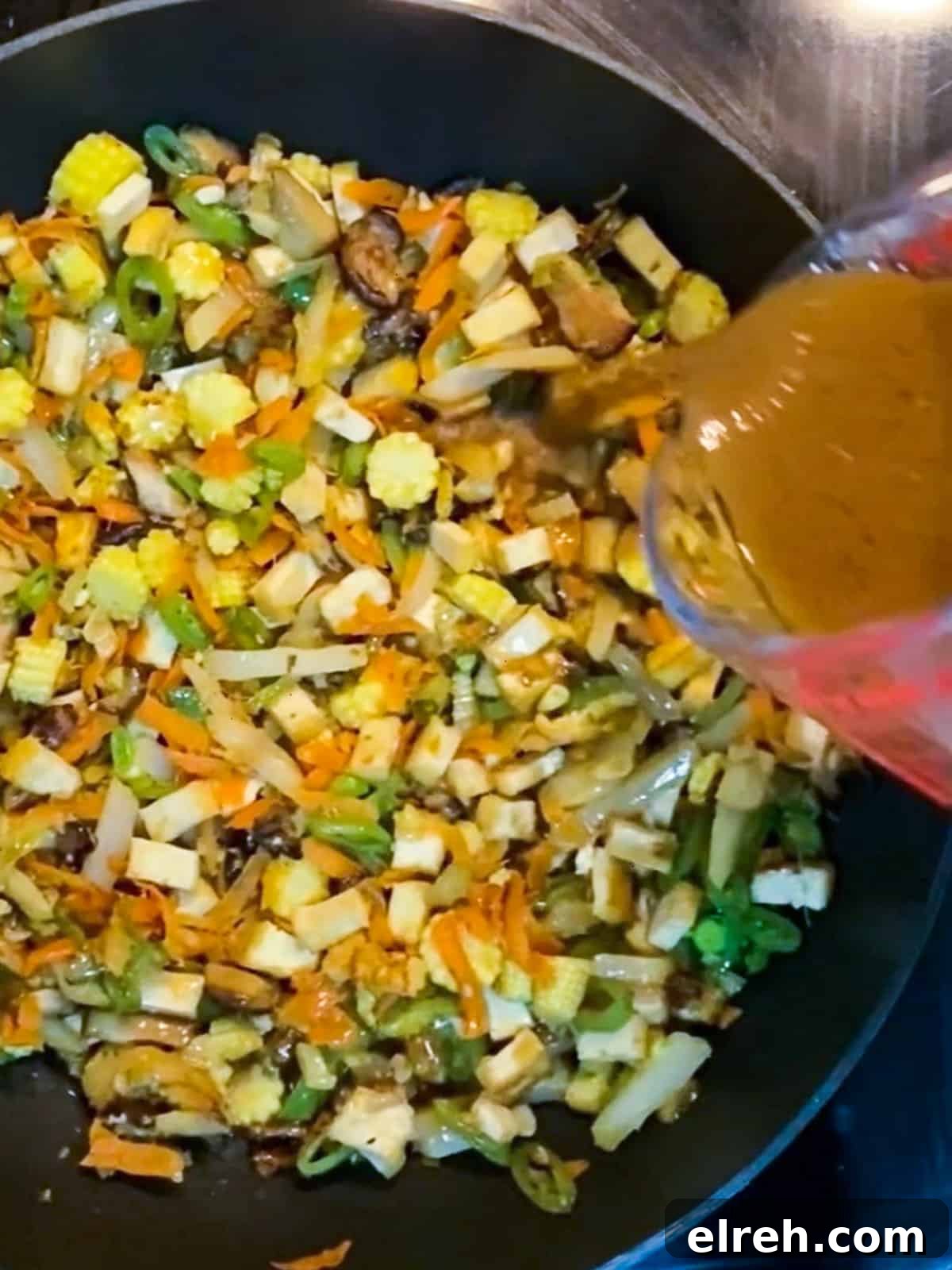 Vegan San Choy Bau Lettuce Cups 9 Photo of sauce being added to the san choy bau mixture in the pan.