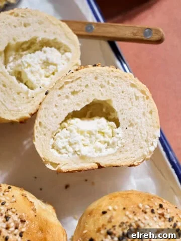 A Sourdough Discard Stuffed Bagel cut in half to show the cream cheese.