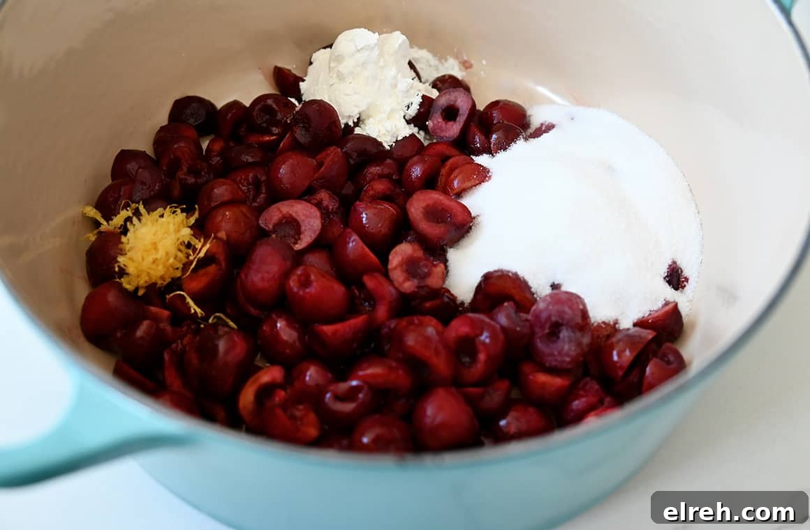 A large saucepan containing fresh cherries, sugar, cornstarch, vanilla extract and lemon zest
