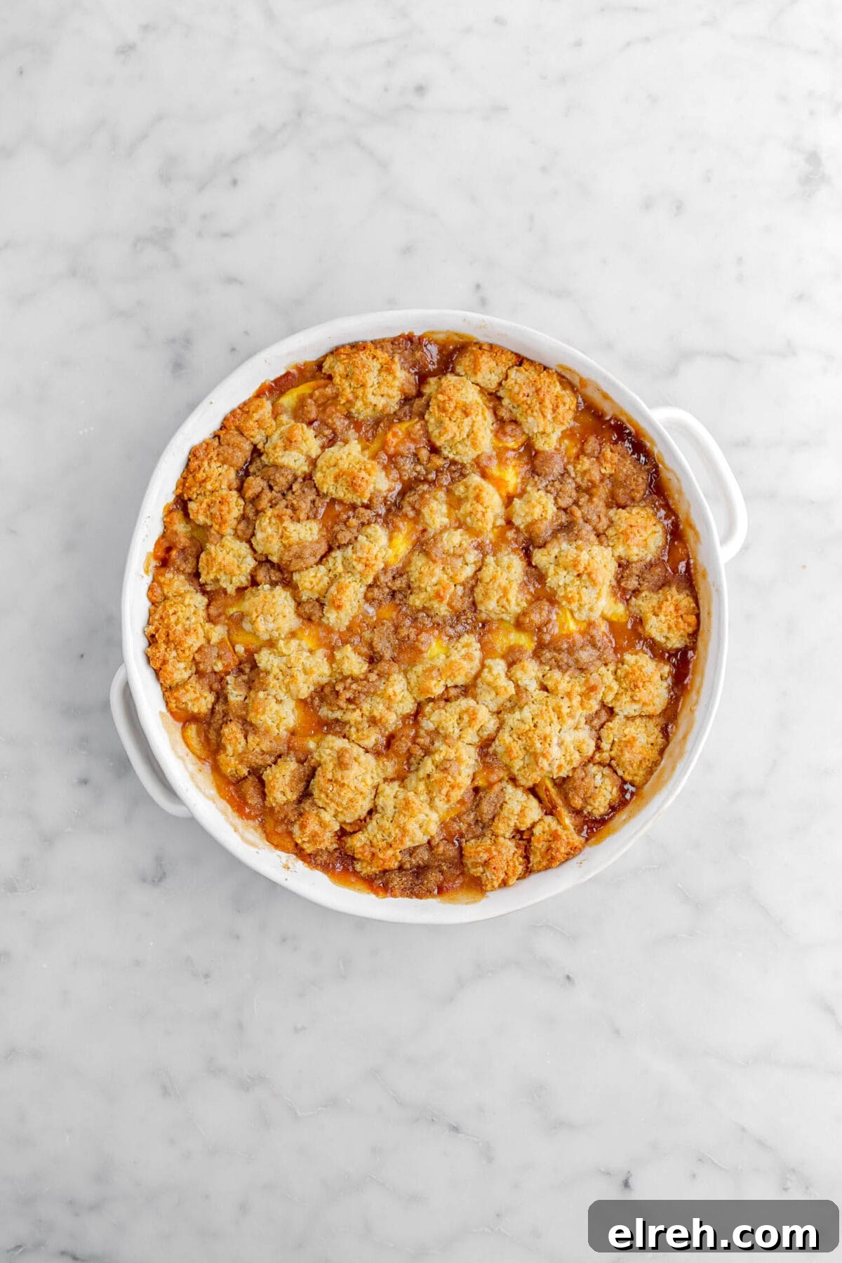 Peach Cobbler Crisp with Brown Sugar and Cinnamon 18 baked peach cobbler on marble surface.