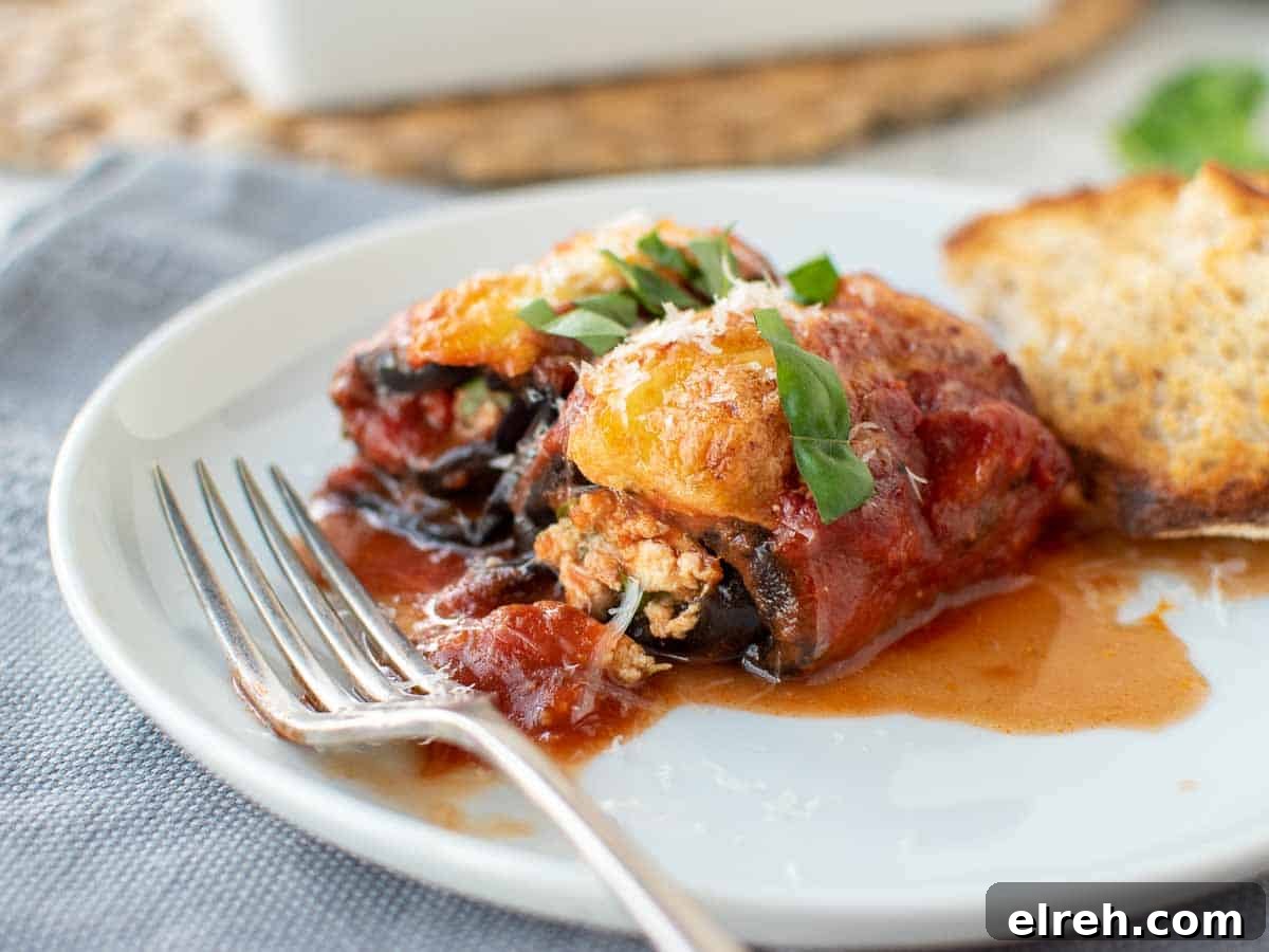 Eggplant Rollatini rolled and filled and topped with tomato sauce and cheese.