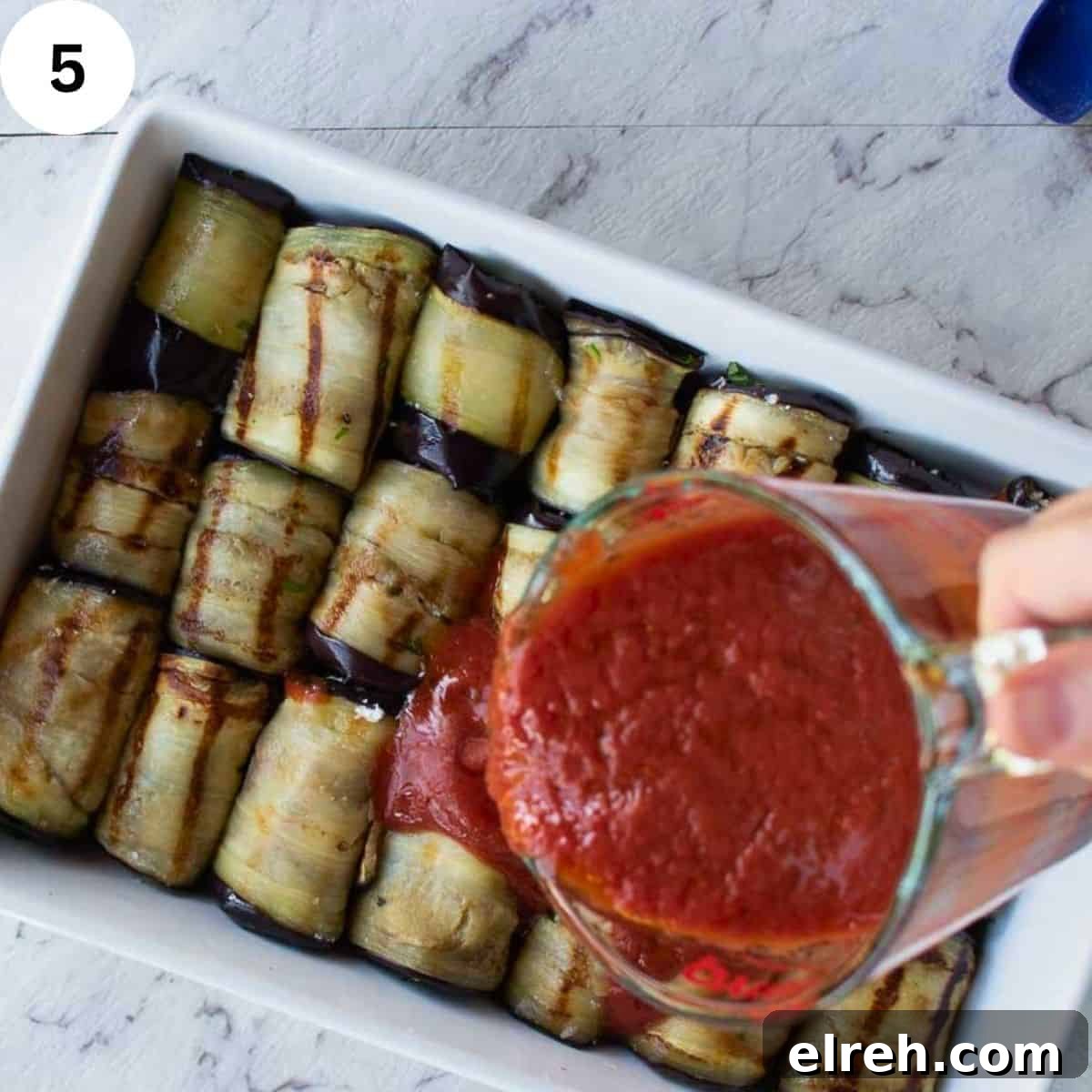 Pouring tomato puree over grilled and rolled eggplant slices.