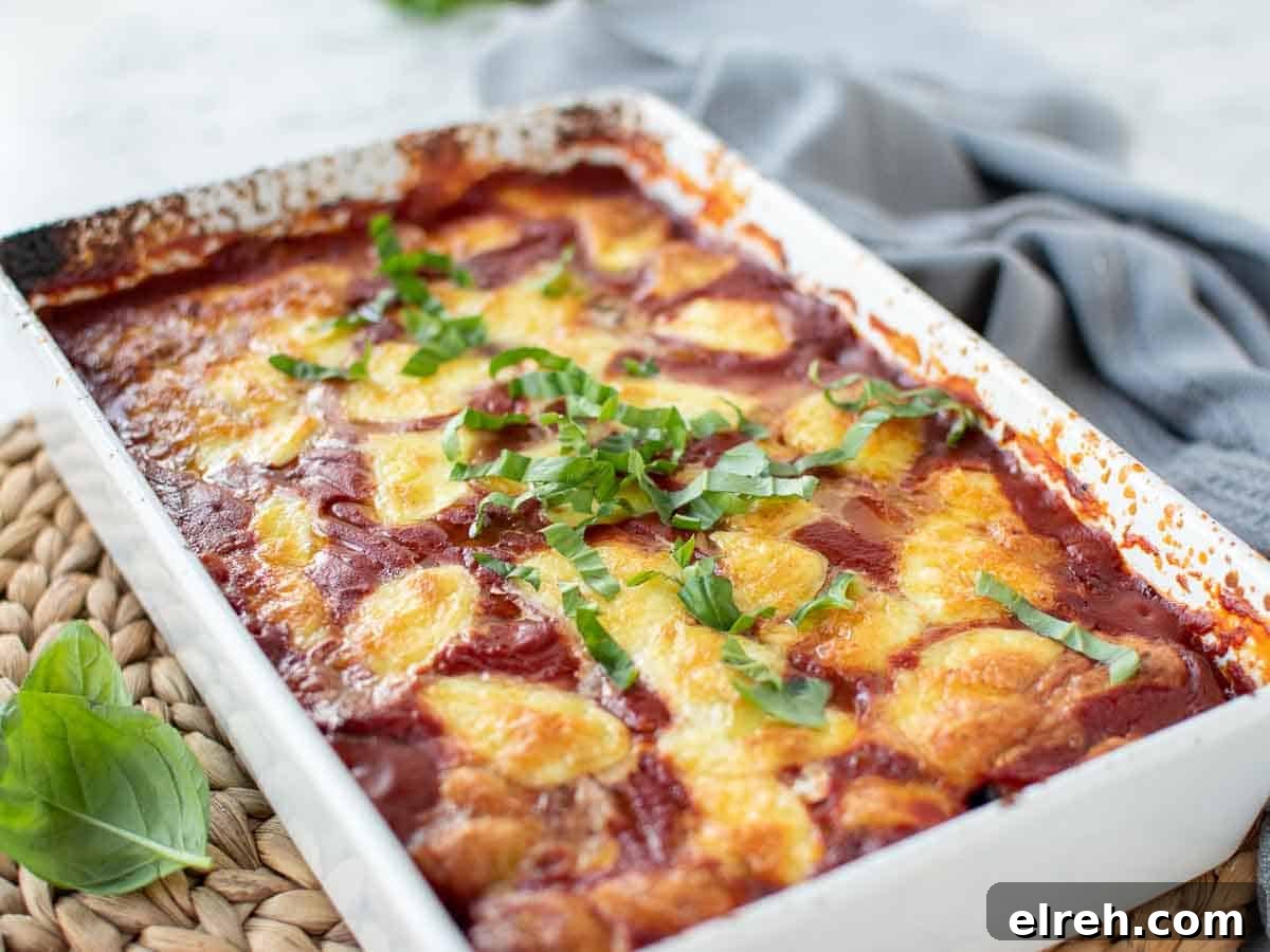 Baked tomato and cheese in a white baking dish.