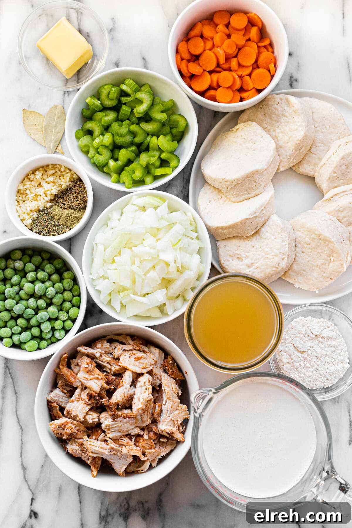 White marble counter top with bowls of ingredients to make homemade chicken and dumpling soup.