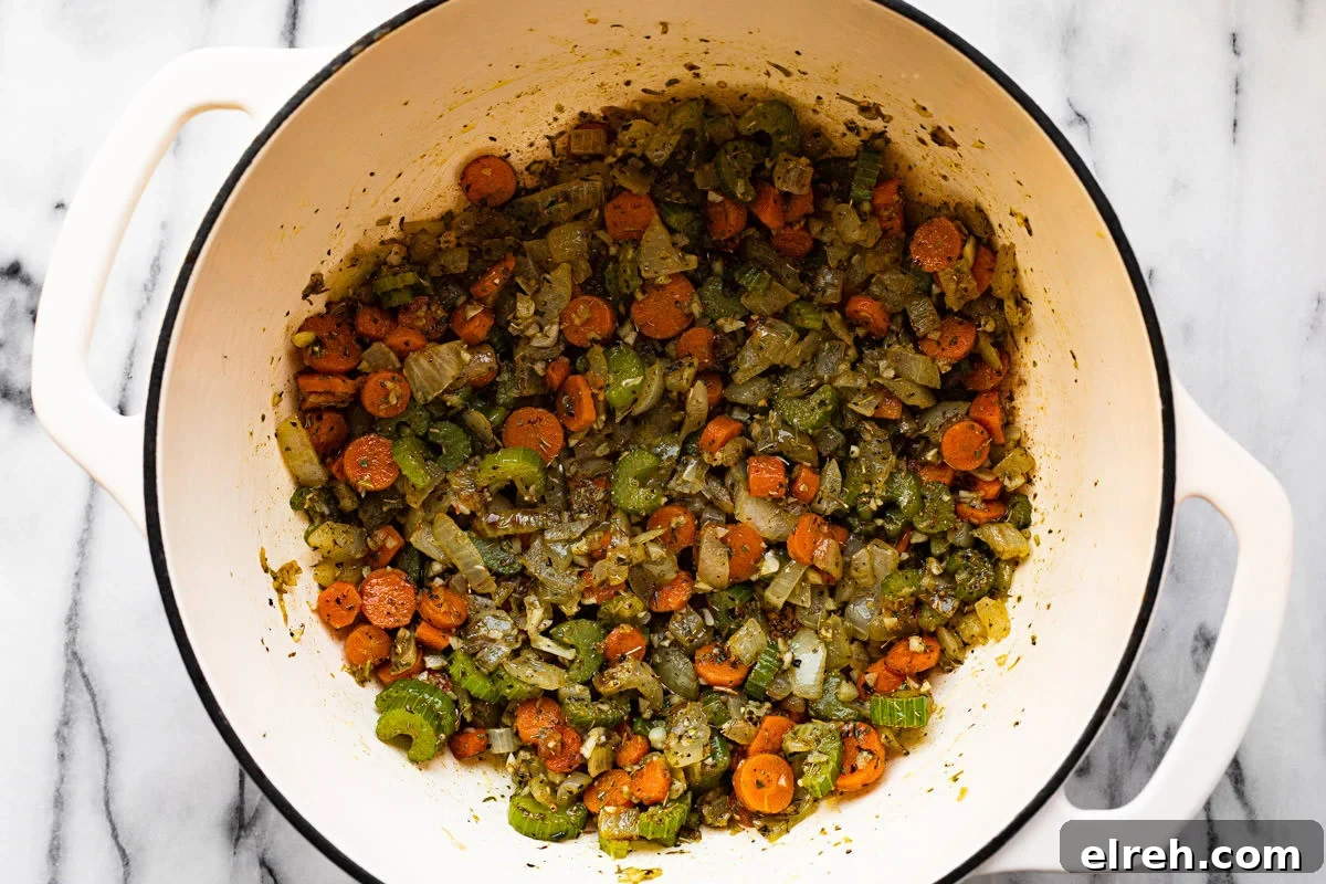 Large white pot filled with sauteed veggies and herbs.