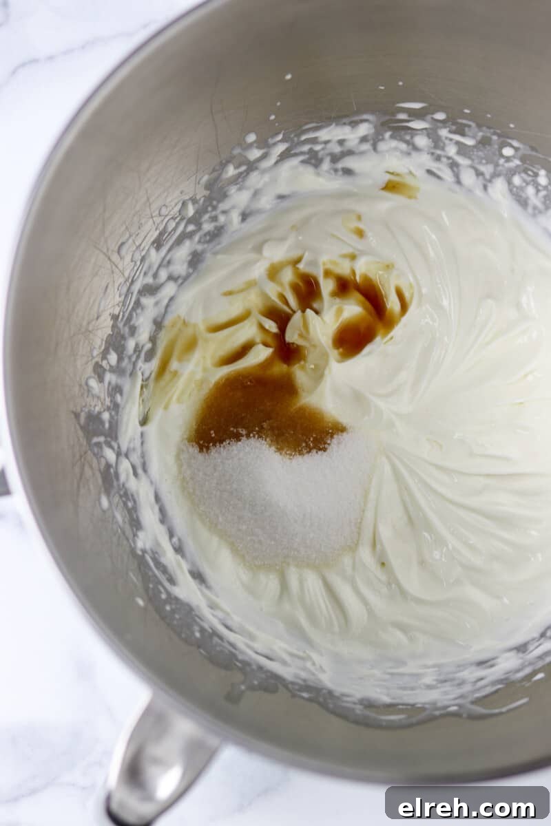 Cream, sugar and vanilla in a metal bowl.