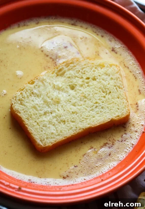 Dipping One Side of Brioche Bread into the French Toast Egg Mixture