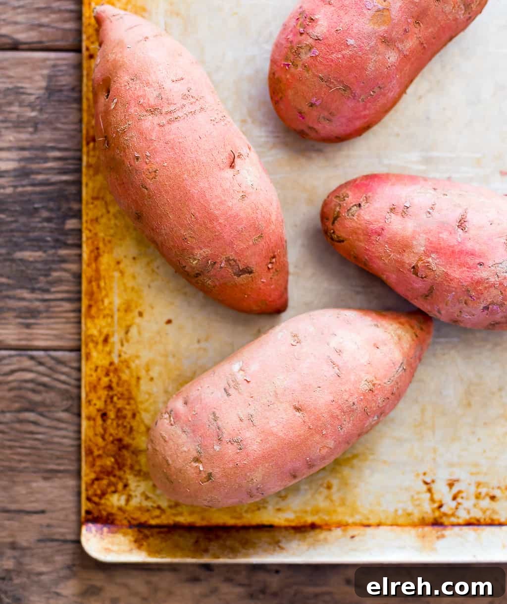 raw sweet potatoes on a sheet pan