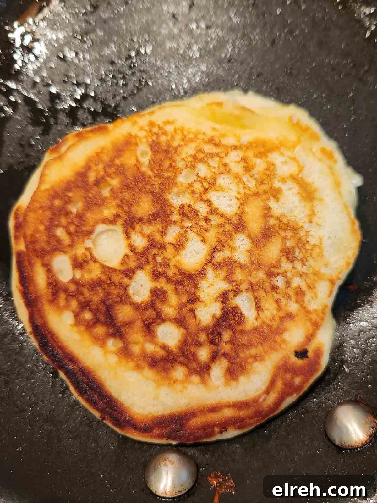 Fluffy Sweet Cream Cinnamon Pancakes Recipe 7 Pancake in a skillet that was just flipped with crispy edges.