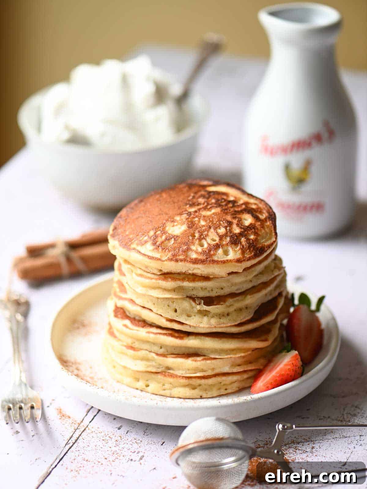 Fluffy Sweet Cream Cinnamon Pancakes Recipe 8 A stack of cinnamon pancakes on a white plate.