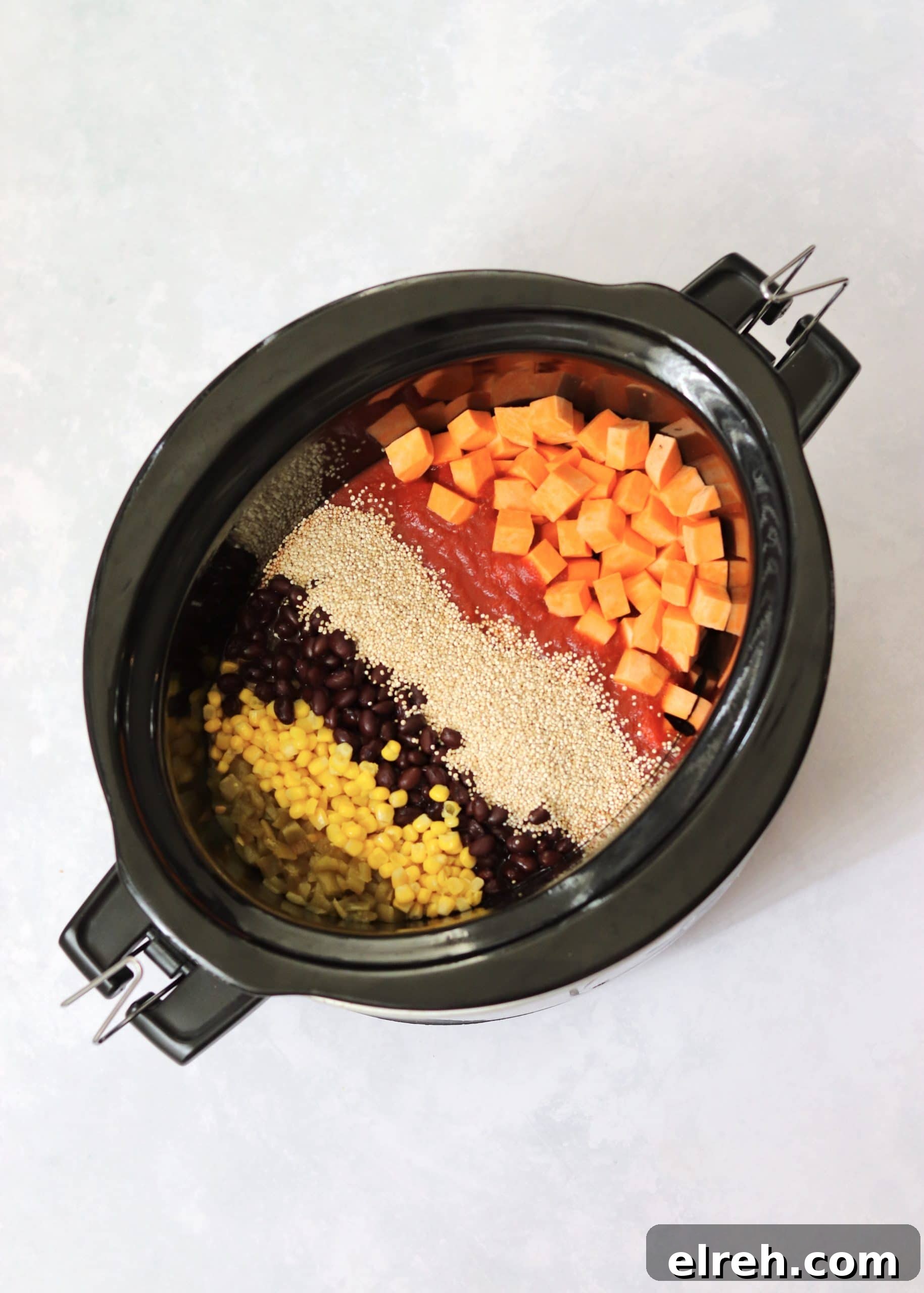 Vegan Slow Cooker Mexican Quinoa Recipe 3 Corn, black beans, quinoa, tomato sauce, and sweet potatoes in a crock pot