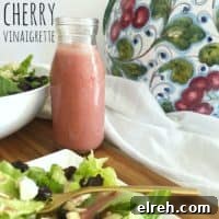 pink bottle of cherry vinaigrette with salad