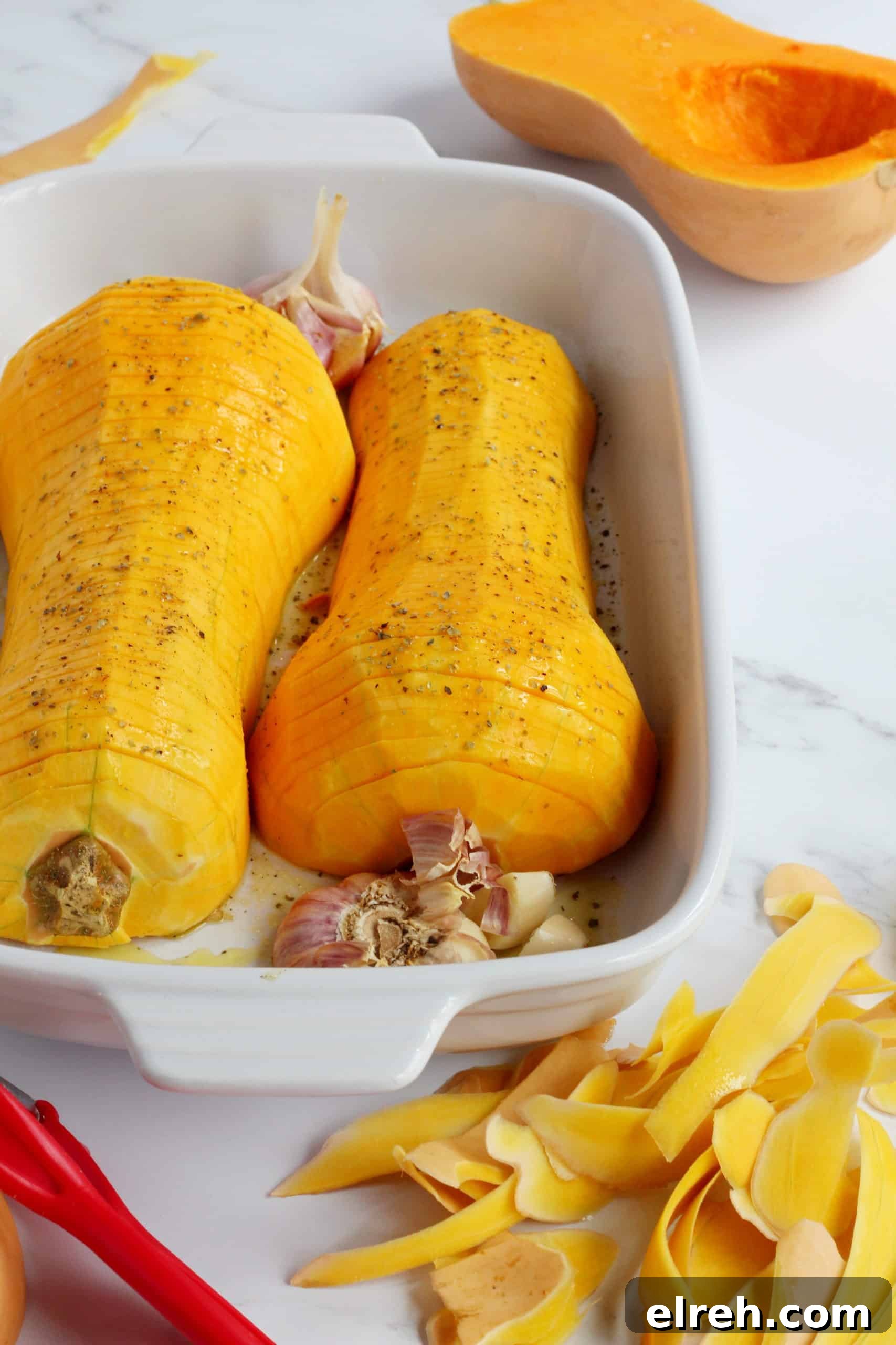 butternut squash cut in half and sliced thinly and placed in white ceramic baking sheet