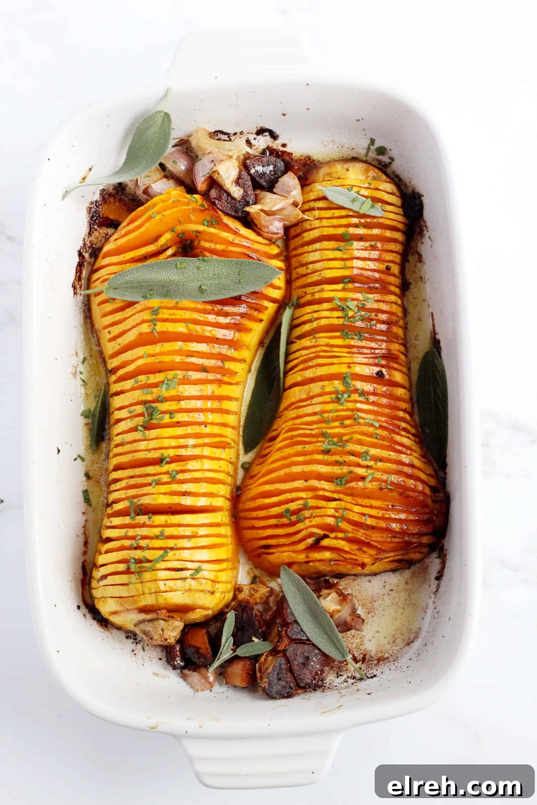 baked butternut squash cut in half and sliced thinly and placed in white ceramic baking sheet