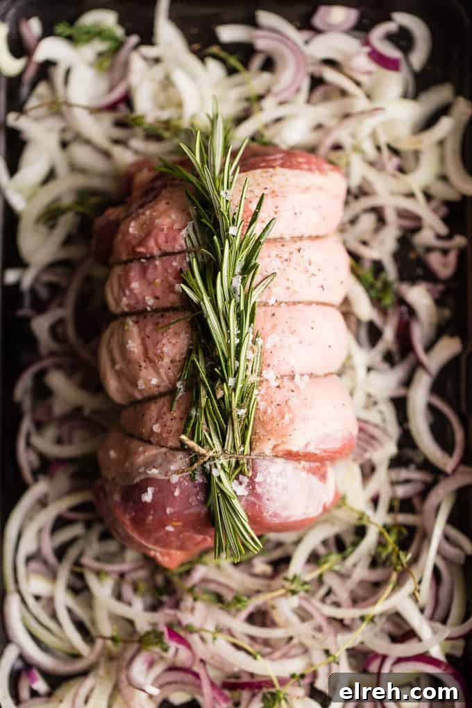 raw leg of lamb tied with twine and rosemary