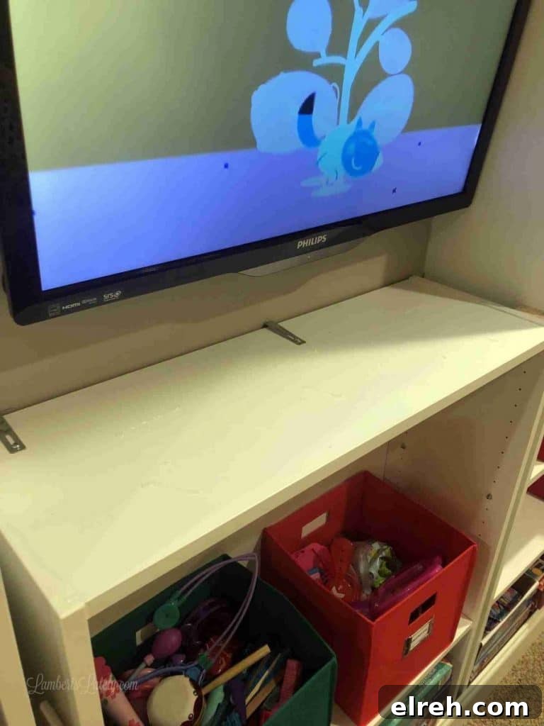 Turn IKEA Billy Bookcases into Built-In Shelving 11 cabinet installed below tv, with metal braces.