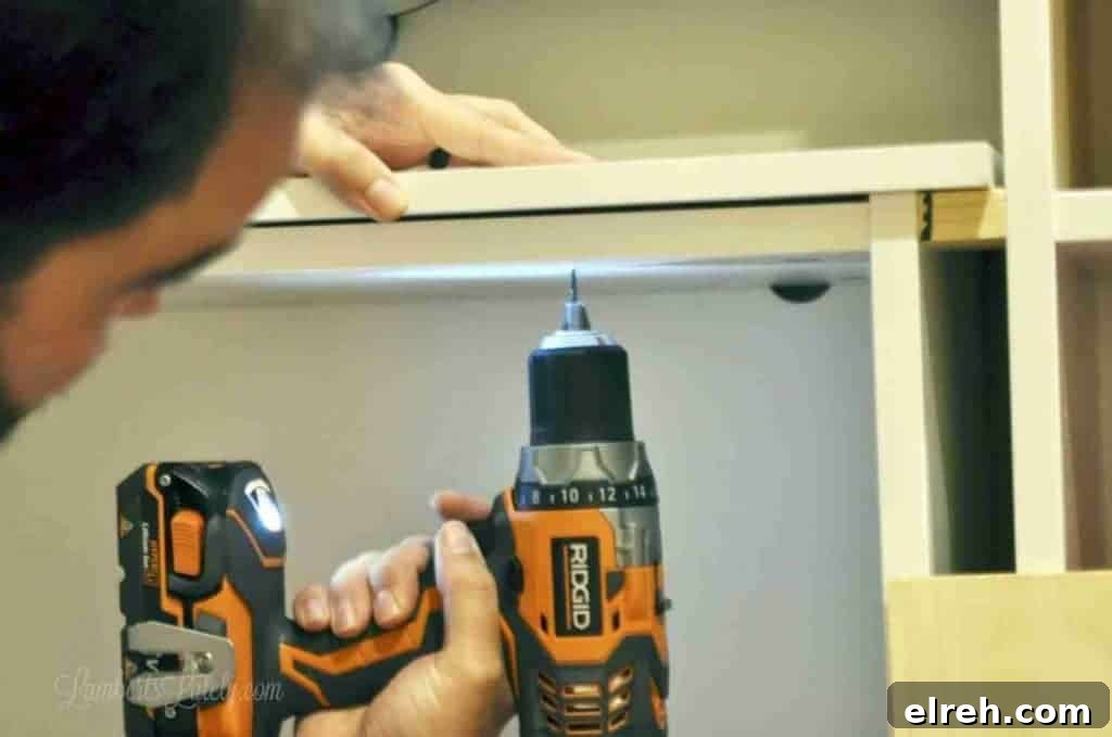 Turn IKEA Billy Bookcases into Built-In Shelving 15 drilling in top of cabinet.