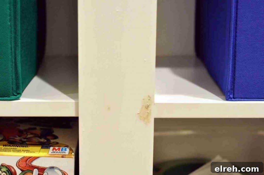 Turn IKEA Billy Bookcases into Built-In Shelving 17 wood putty over a hole in white shelf.