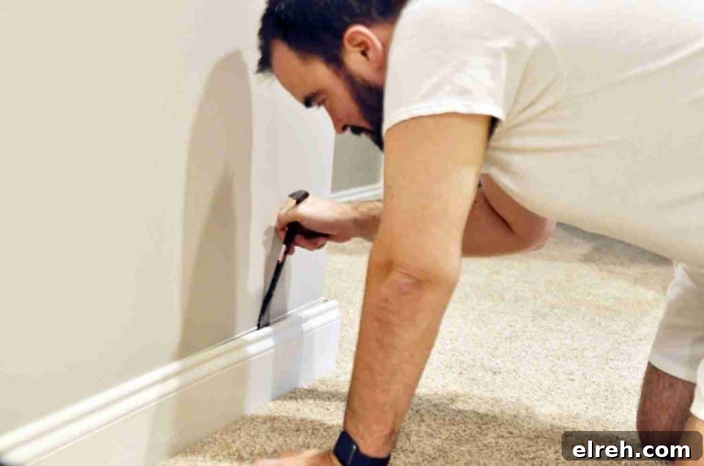 Turn IKEA Billy Bookcases into Built-In Shelving 8 taking baseboard off of a wall.