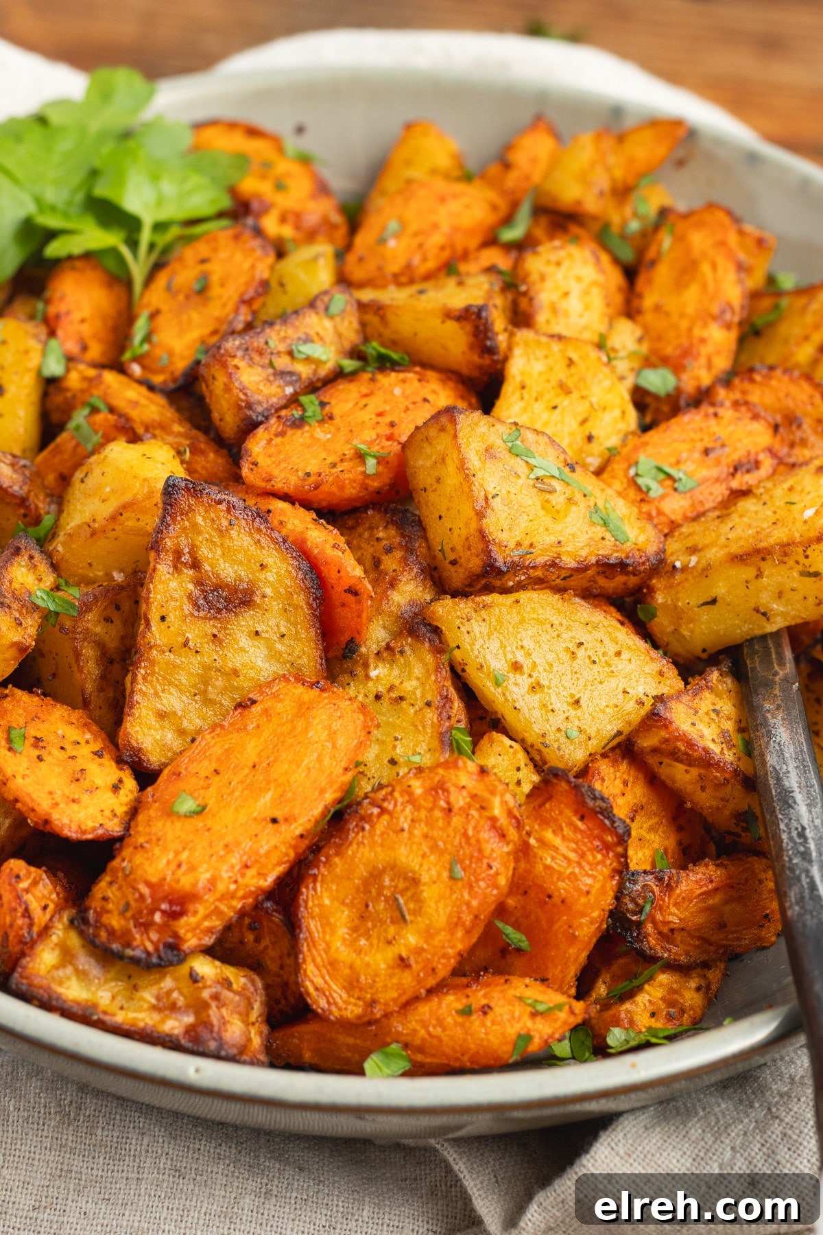 Bowl filled with cooked air fryer carrots and potatoes.