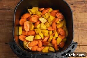 Seasoned vegetables in the air fryer before cooking.