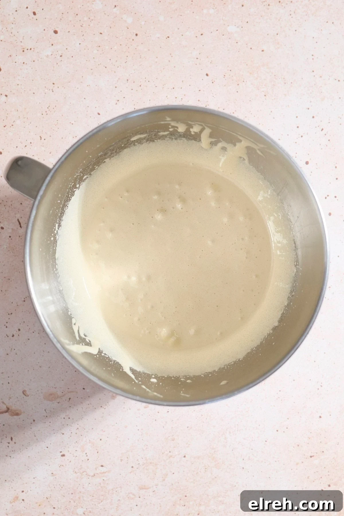 Eggs and sugar whipped in the bowl of a stand mixer.