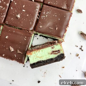 a close up of a square of chocolate mint cheesecake turned diagonal to see the layers.