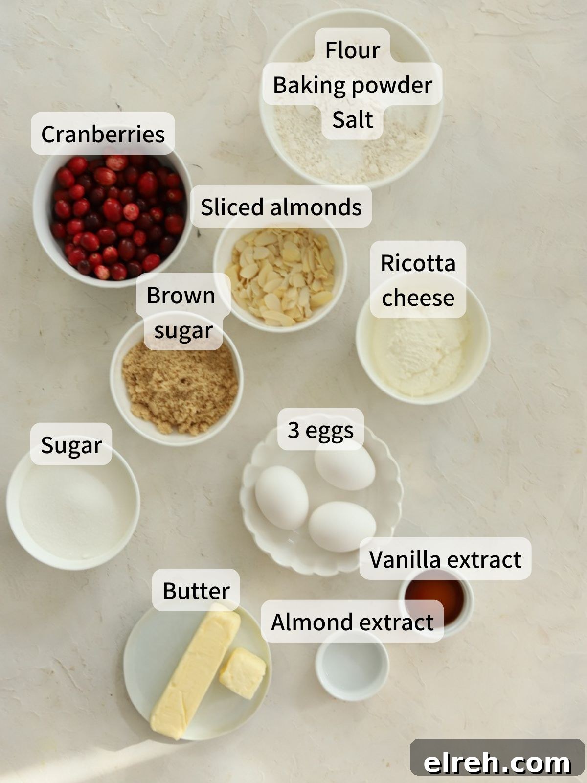 Labeled ingredients for cranberry ricotta cake laid out on a table