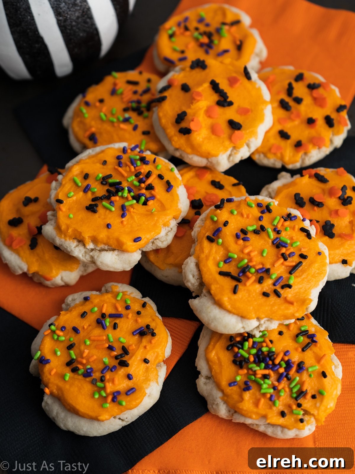 Lofthouse frosted sugar cookies topped with orange frosting and Halloween sprinkles.