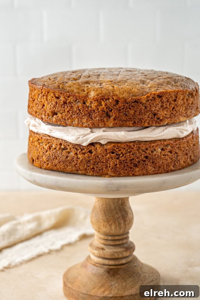 The cake layered with buttercream on a cake stand.