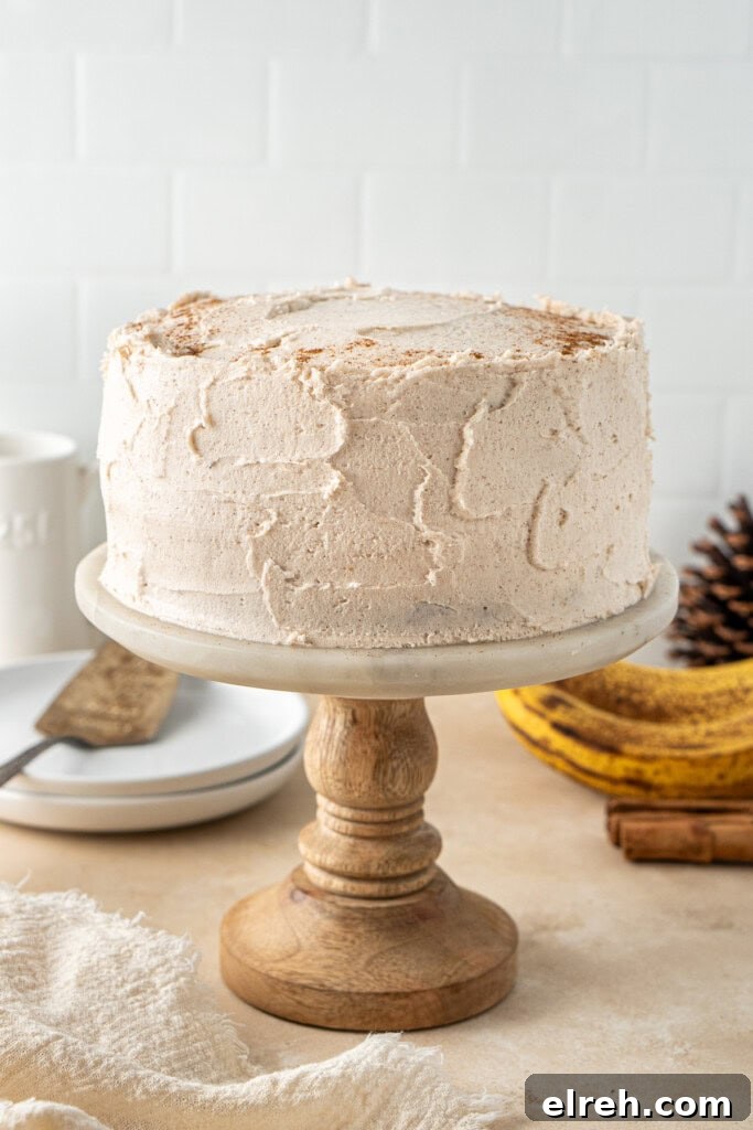 The frosted cake on a cake stand.